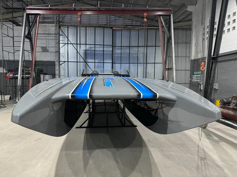 Slide: The Image of 2025 Statement 396 Cat boat in a warehouse, showcasing sleek design and blue accents. - 9