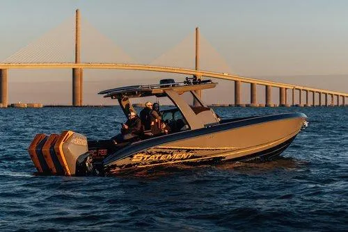 Slide: The Image of 2026 Statement 35 CC Open boat cruising near a bridge at sunset. - 10