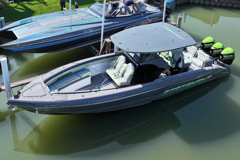 Slide: The Image of 2026 Statement 35 CC Open boat with sleek design and vibrant green accents docked in water. - 3