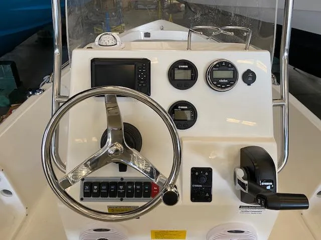 Slide: The Image of 2023 Key West 1720CC boat dashboard with steering wheel, gauges, and controls. - 5