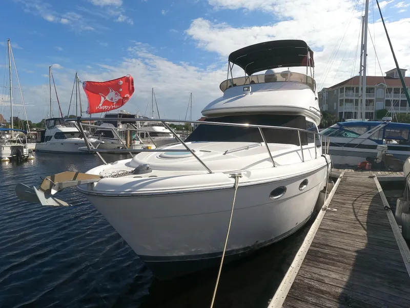 The Image of 2003 Meridian 341 Sedan yacht docked at a marina with a red flag. - 0