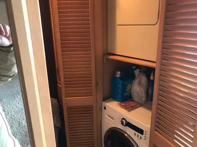 Slide: The Image of Laundry area in a 1997 Stardust Cruisers houseboat with washer, dryer, and cleaning supplies. - 12