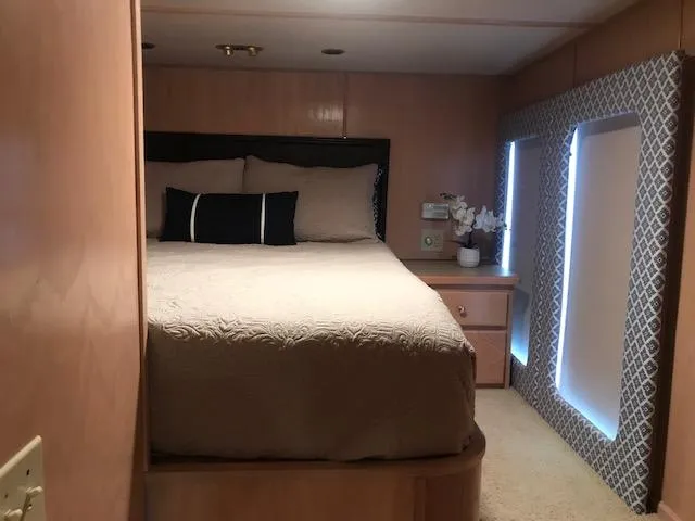 Slide: The Image of Cozy bedroom interior of 1997 Stardust Cruisers houseboat with bed and decorative windows. - 22