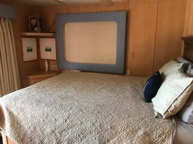 Slide: The Image of Cozy bedroom interior of 1997 Stardust Cruisers houseboat with quilted bedding and wooden decor. - 24