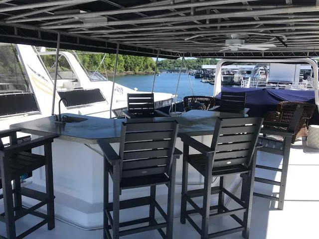 Slide: The Image of 1997 Stardust Cruisers houseboat with outdoor seating and bar on a sunny day. - 29