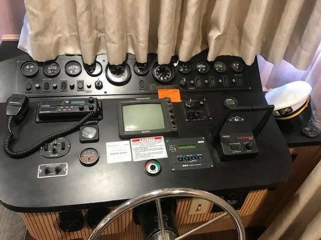 Slide: The Image of 1997 Stardust Cruisers houseboat control panel with gauges, steering wheel, and communication equipment. - 3