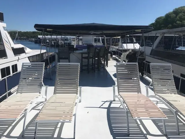 Slide: The Image of 1997 Stardust Cruisers houseboat with sun loungers on deck, docked at marina. - 30