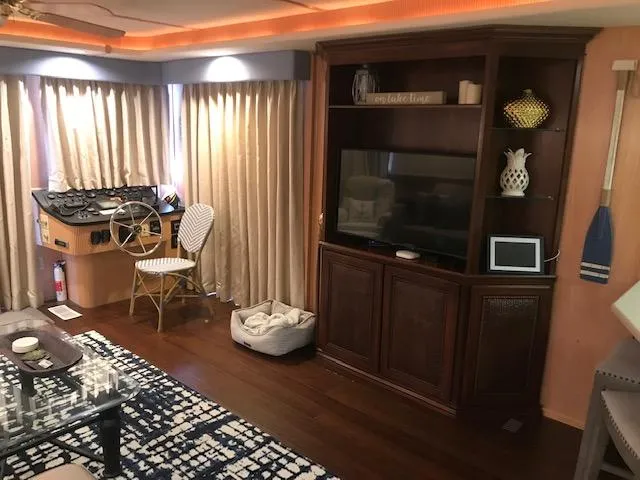 Slide: The Image of 1997 Stardust Cruisers houseboat interior with helm, entertainment center, and cozy decor. - 5