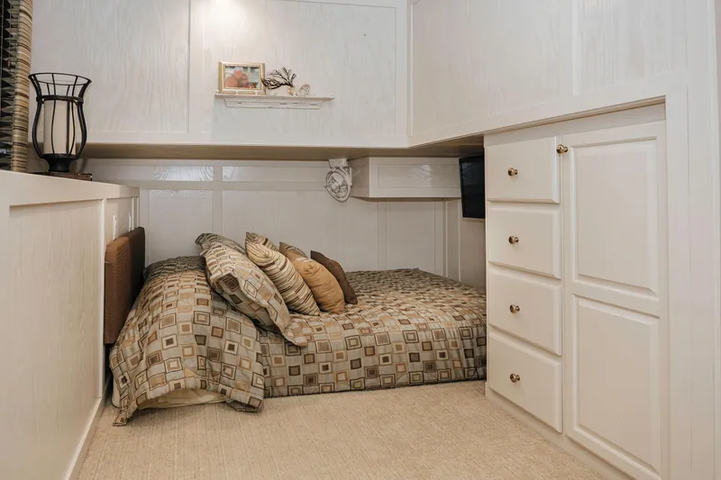 Slide: The Image of Cozy bedroom in 1996 Sumerset houseboat with patterned bedding and white cabinetry. - 12