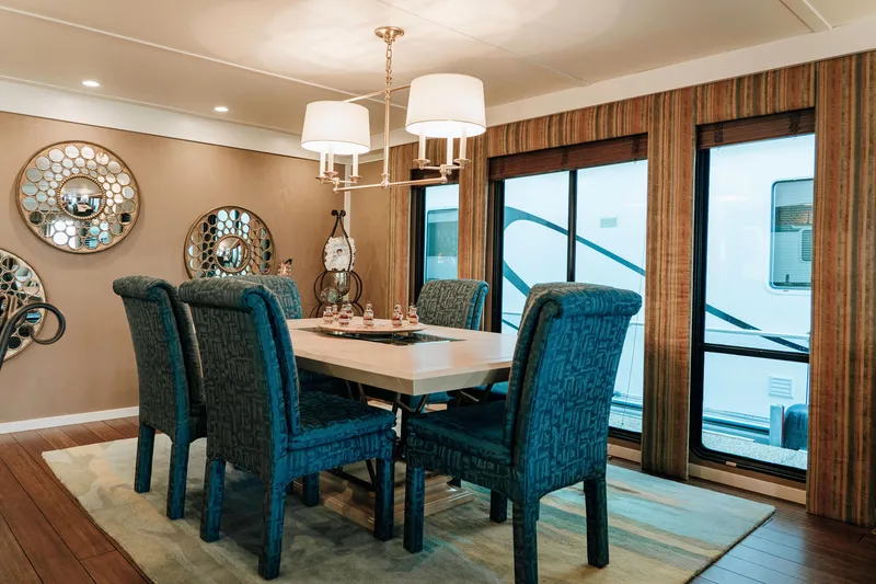 Slide: The Image of Luxurious dining area in a 1996 Sumerset houseboat with elegant decor and blue upholstered chairs. - 7