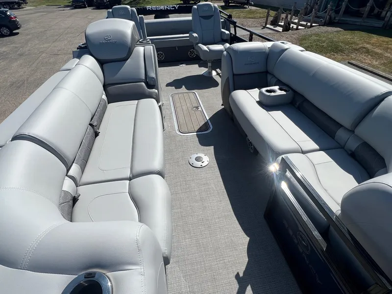 Slide: The Image of 2023 Regency 230 LE3 Sport pontoon boat interior with plush seating and cup holders. - 1