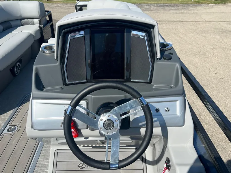 Slide: The Image of 2023 Regency 230 LE3 Sport boat dashboard with steering wheel and control panel. - 5