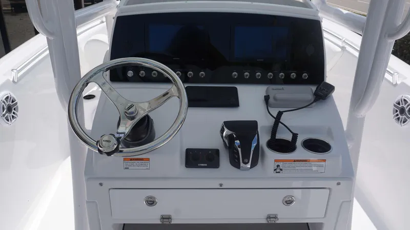 Slide: The Image of 2023 Sportsman 231 Heritage boat dashboard with steering wheel, controls, and Garmin displays. - 3