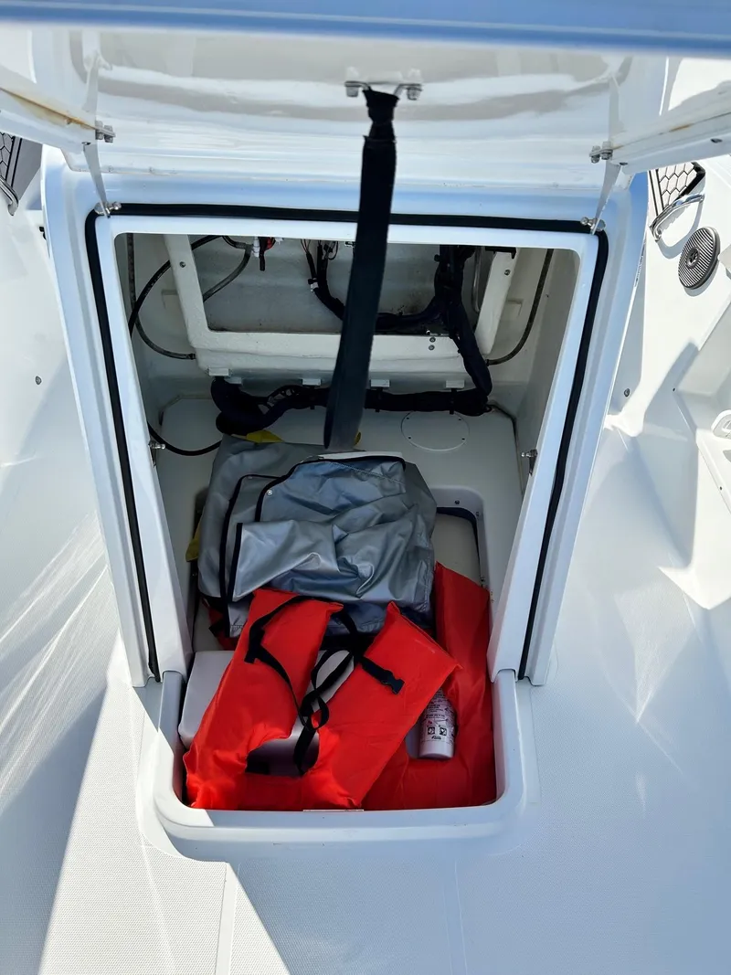 Slide: The Image of 2020 Scarab 195 Open ID boat storage compartment with life jackets and gear. - 12