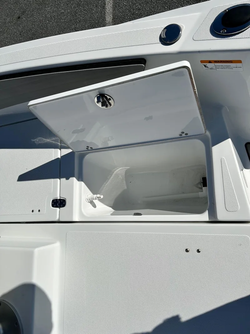 Slide: The Image of 2020 Scarab 195 Open ID boat storage compartment open on deck. - 26