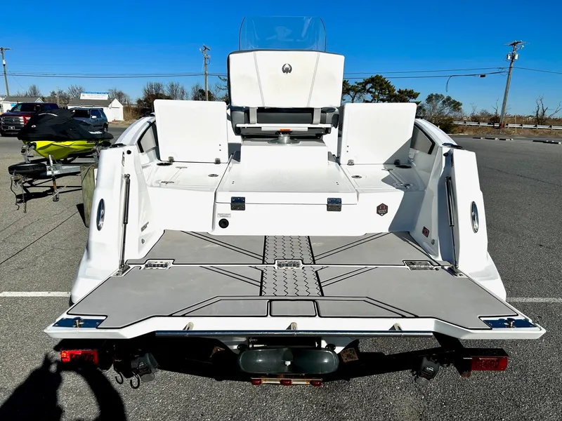 Slide: The Image of 2020 Scarab 195 Open ID boat, rear view, parked on asphalt under clear blue sky. - 39