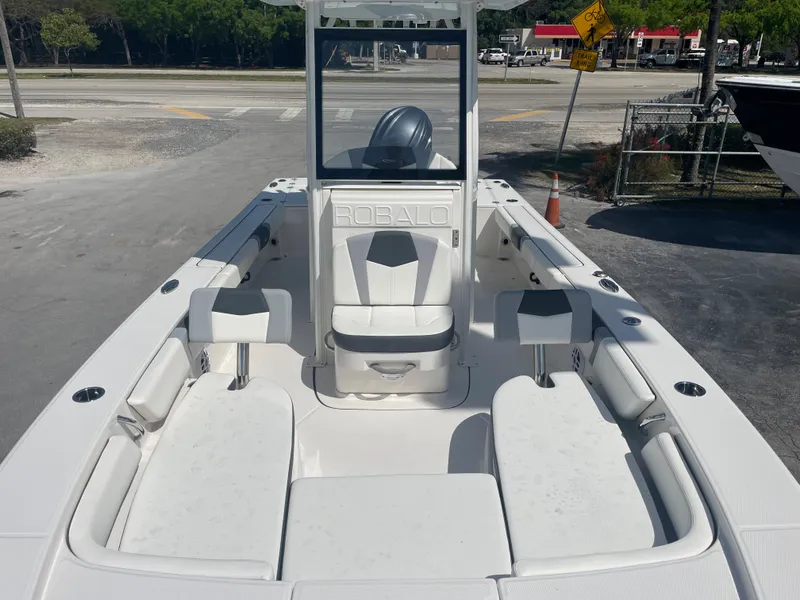 Slide: The Image of 2023 Robalo 246 Cayman boat interior with seating and console, parked on a lot. - 11