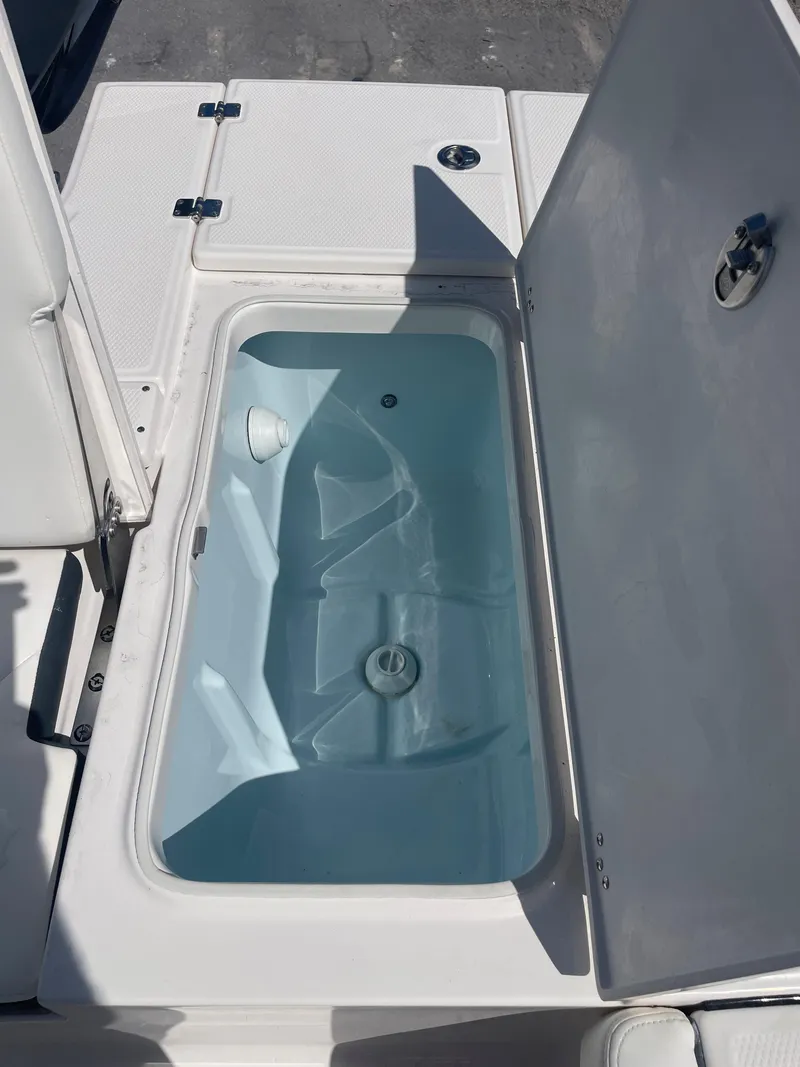 Slide: The Image of 2023 Robalo 246 Cayman livewell with open lid, showcasing interior design. - 17
