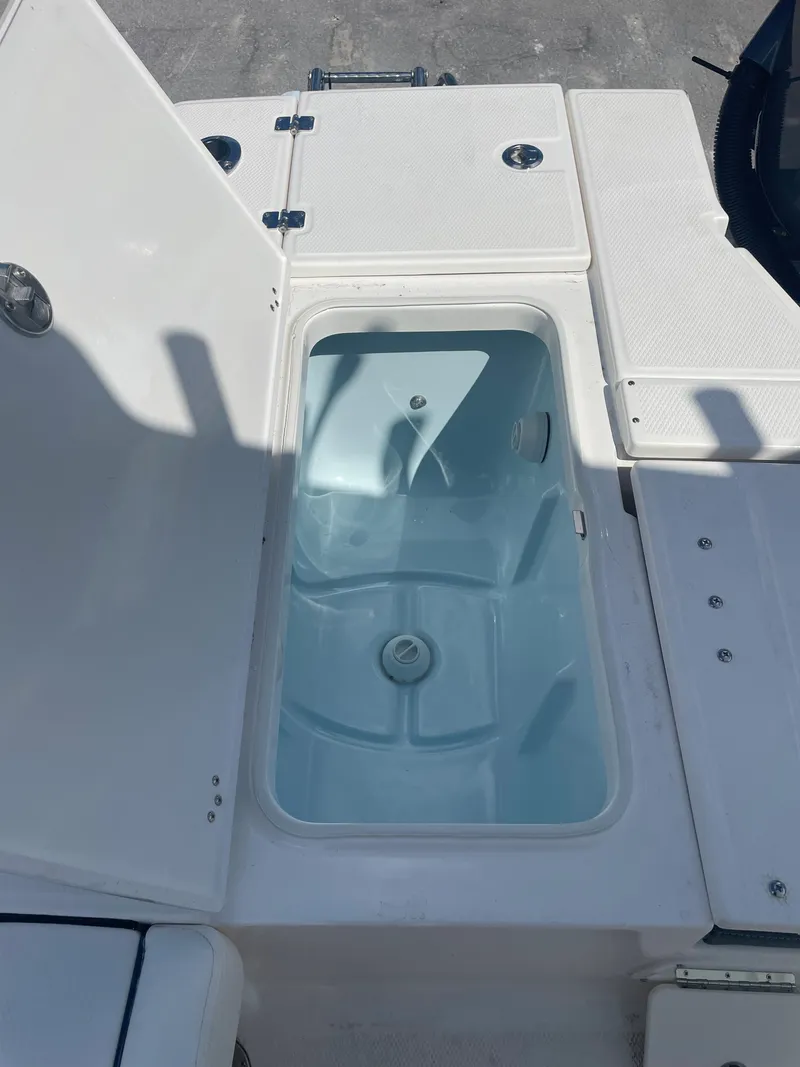 Slide: The Image of 2023 Robalo 246 Cayman boat storage compartment with open lid. - 18