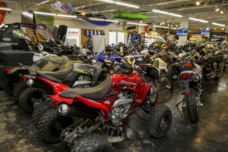 Slide: The Image of Showroom filled with various ATVs and motorcycles, featuring brands like Suzuki and Yamaha. - 26