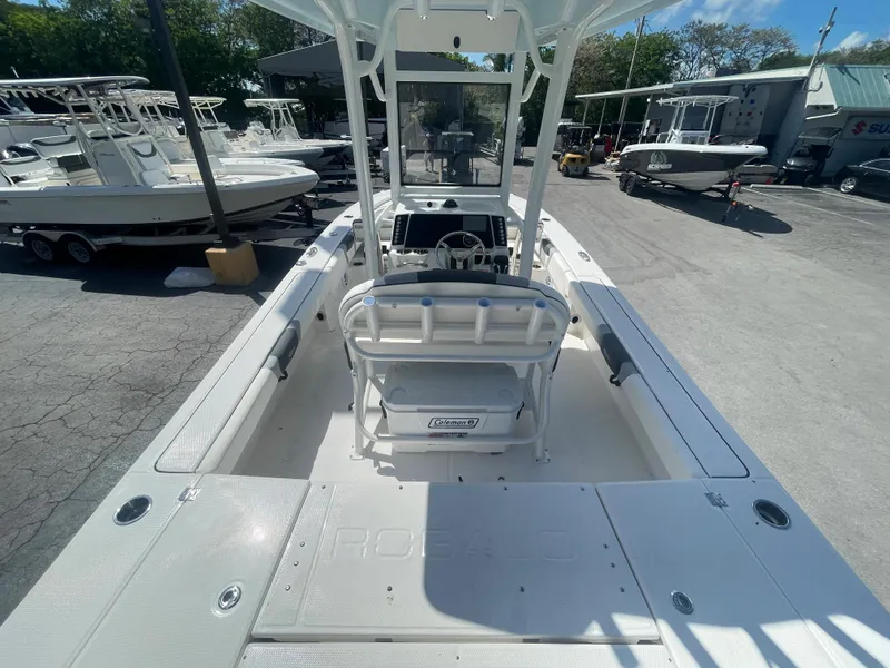 Slide: The Image of 2023 Robalo 246 Cayman boat interior, featuring helm and seating, in a marina setting. - 5