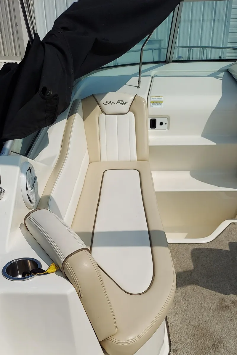 Slide: The Image of 2012 Sea Ray 240 Sundancer boat interior with beige seating and cup holder. - 10