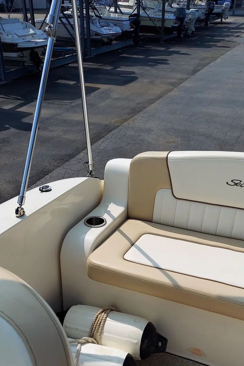 Slide: The Image of 2012 Sea Ray 240 Sundancer boat interior with beige seating and cup holder. - 11
