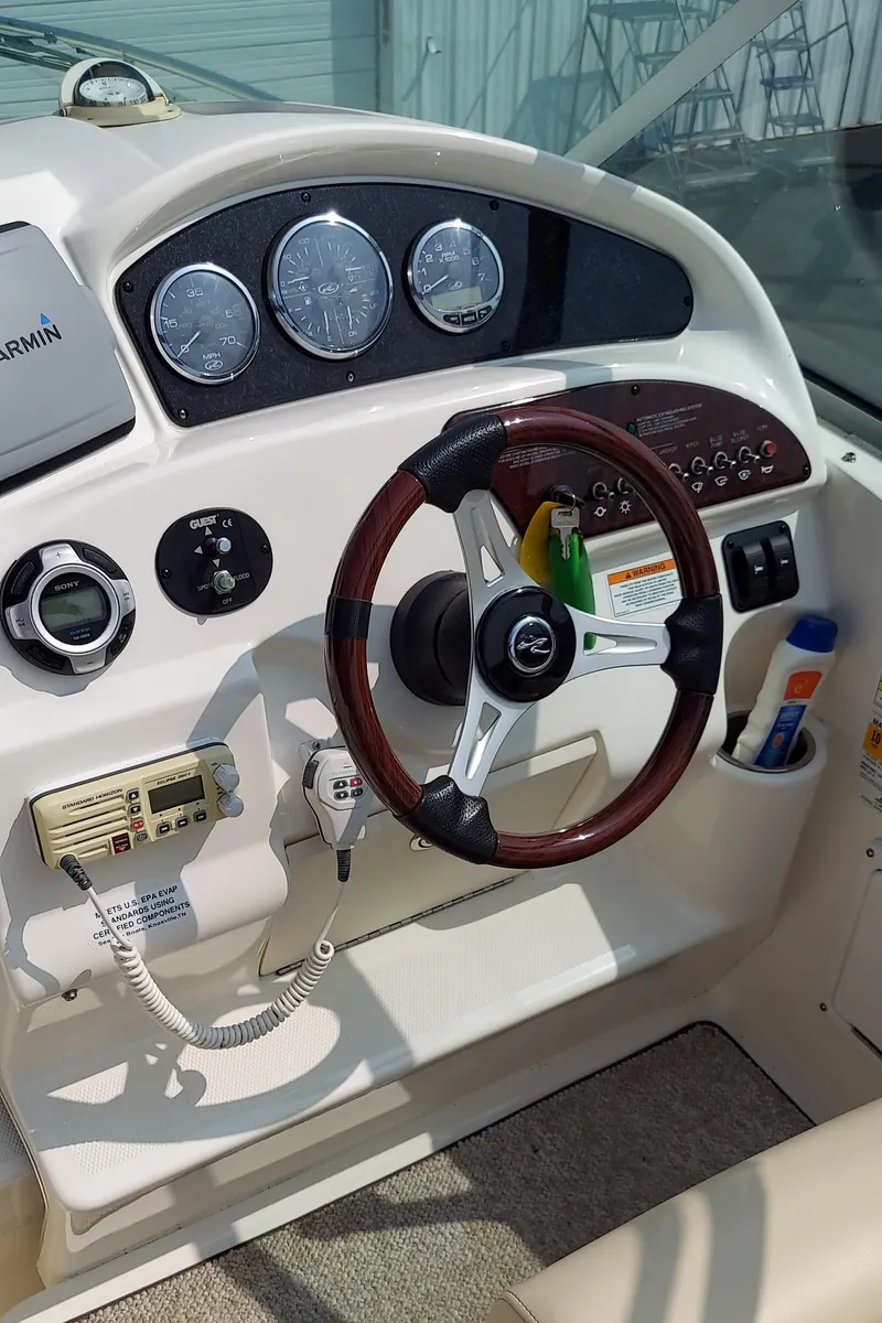 Slide: The Image of 2012 Sea Ray 240 Sundancer boat helm with steering wheel and instrument panel. - 12