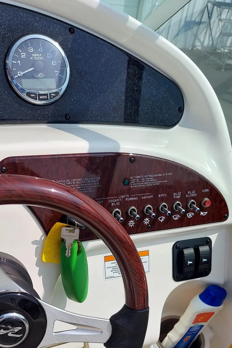Slide: The Image of Control panel of a 2012 Sea Ray 240 Sundancer boat with steering wheel and gauges. - 14