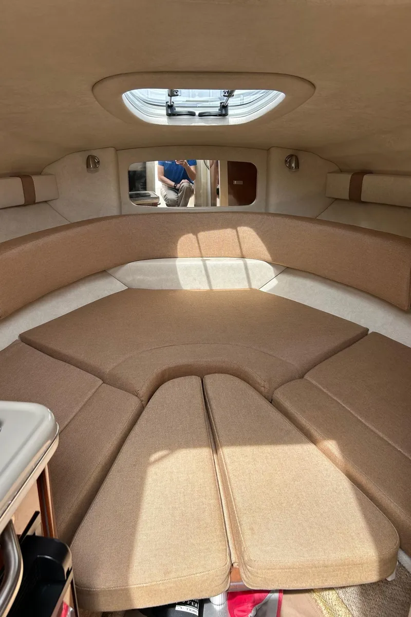 Slide: The Image of 2012 Sea Ray 240 Sundancer cabin interior with beige upholstery. - 28