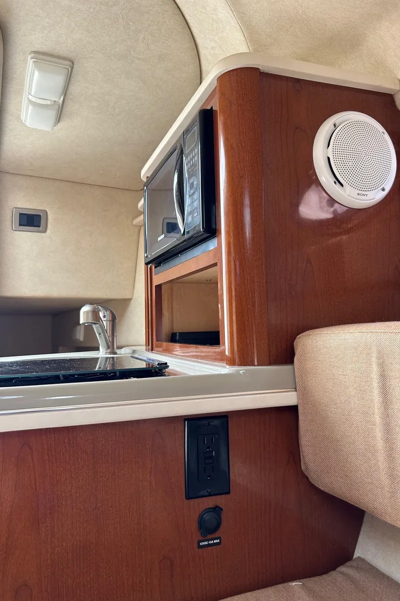Slide: The Image of 2012 Sea Ray 240 Sundancer cabin interior with kitchenette and microwave. - 31