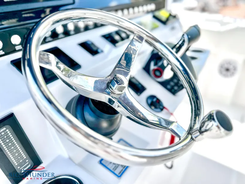 Slide: The Image of Close-up of the steering wheel and controls of a 2023 Fountain 38 CC boat. - 24