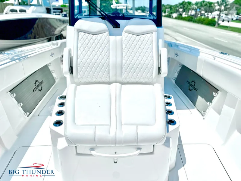 Slide: The Image of 2023 Fountain 38 CC boat interior with white cushioned seating and Big Thunder Marine logo. - 44