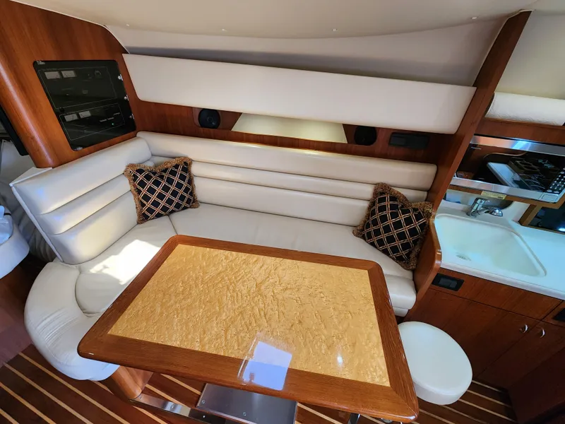 Slide: The Image of 2005 Tiara Yachts 3800 Open interior with white leather seating and wooden table. - 22