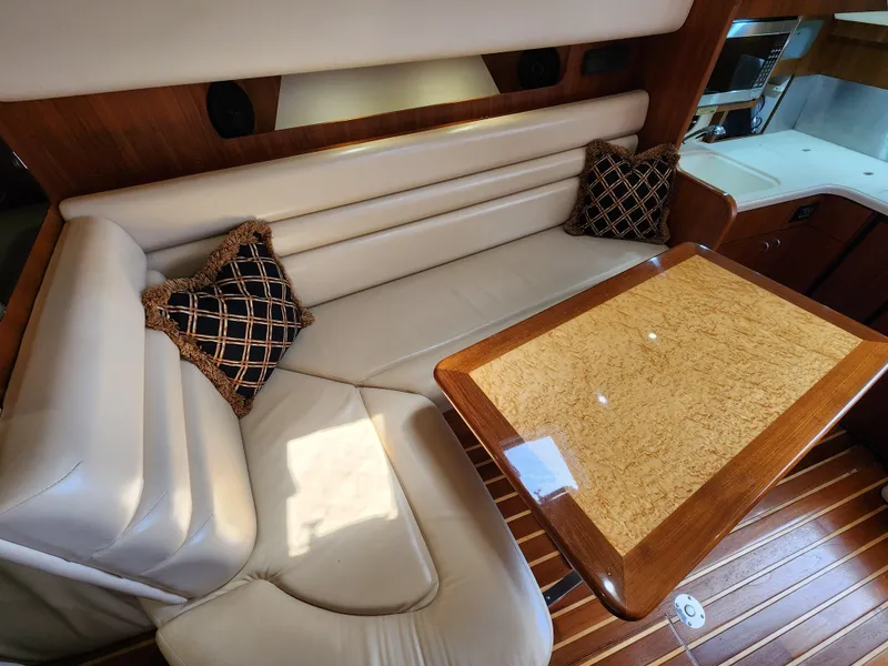 Slide: The Image of 2005 Tiara Yachts 3800 Open interior with white leather seating and wooden table. - 23