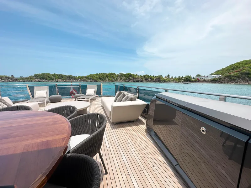 Slide: The Image of Luxurious 2021 Princess X95 yacht deck with elegant seating, overlooking serene blue waters and lush greenery. - 31