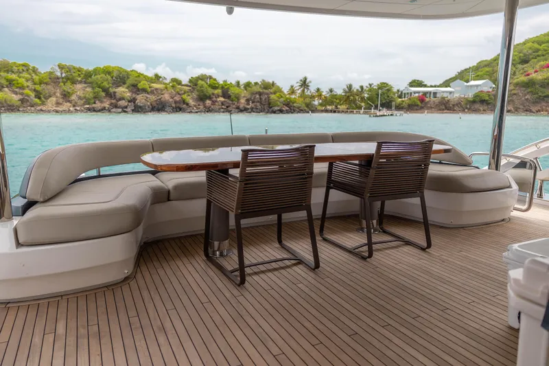 Slide: The Image of Luxury yacht Princess X95 deck with seating and table, overlooking serene coastal waters. - 41
