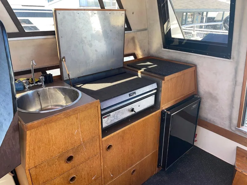 Slide: The Image of 1985 Nord West 900 boat interior kitchen with sink, stove, and mini-fridge. - 11