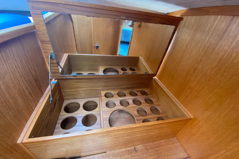 Slide: The Image of Wooden storage compartment with circular cutouts in a 1985 Nord West 900 boat. - 22