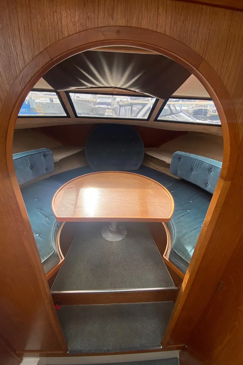 Slide: The Image of Interior of 1985 Nord West 900 boat with wooden table and blue seating. - 23