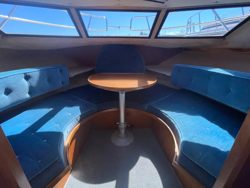 Slide: The Image of Interior of 1985 Nord West 900 boat with blue cushioned seating and wooden table. - 24