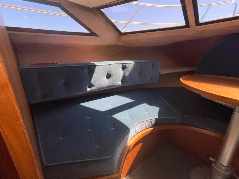 Slide: The Image of Interior seating area of a 1985 Nord West 900 boat with blue cushions and wooden table. - 25