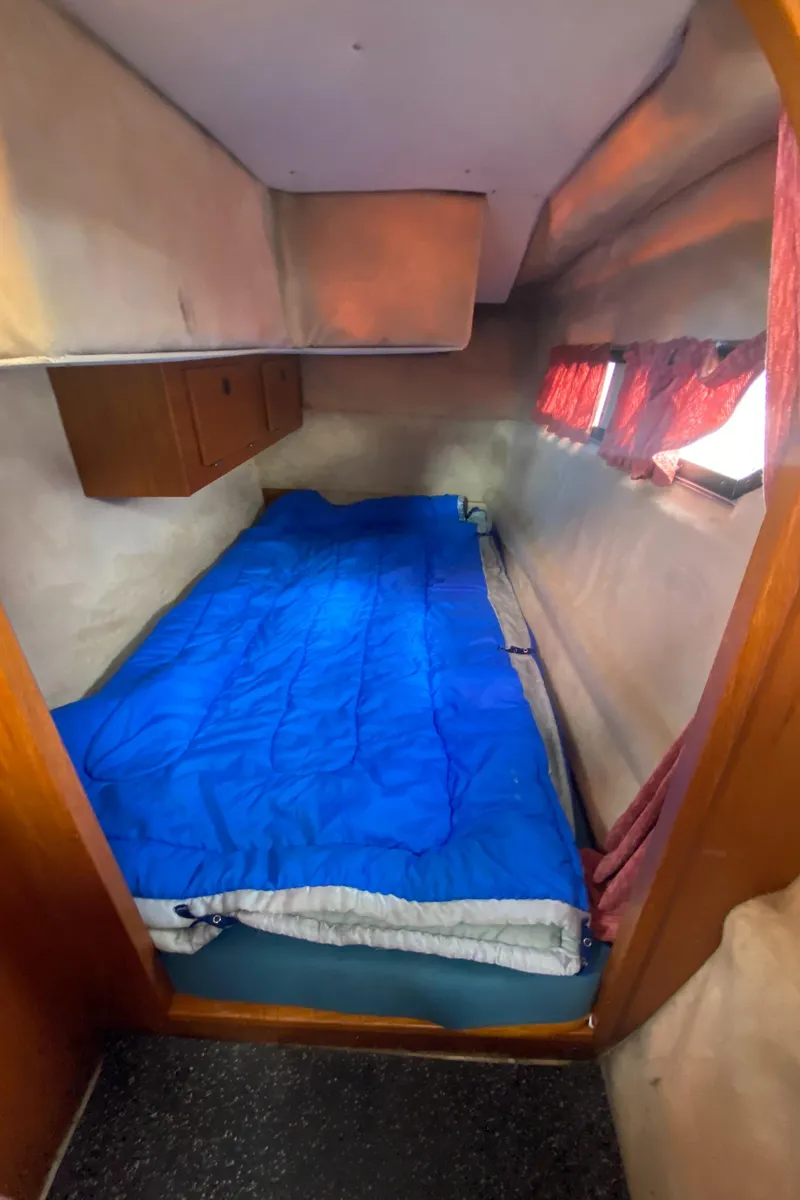 Slide: The Image of Cozy cabin bed in a 1985 Nord West 900 boat with blue bedding. - 27