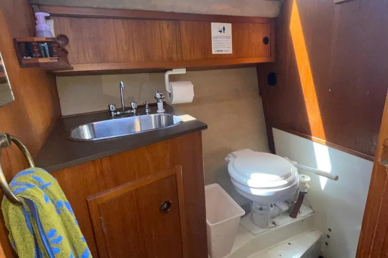 Slide: The Image of 1985 Nord West 900 boat bathroom with sink, toilet, and wooden cabinetry. - 29