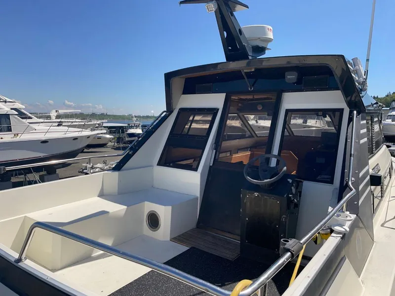 Slide: The Image of 1985 Nord West 900 boat docked at marina, featuring spacious cockpit and modern navigation equipment. - 4