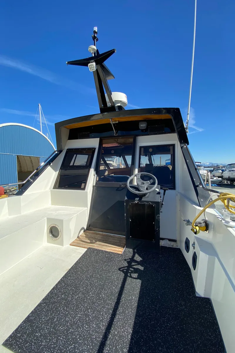 Slide: The Image of 1985 Nord West 900 boat cockpit with steering wheel and control panel. - 8