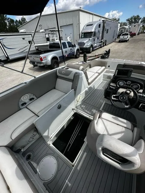 Slide: The Image of 2019 Crownline 205XS boat interior with open storage compartments, steering wheel, and seating. - 13