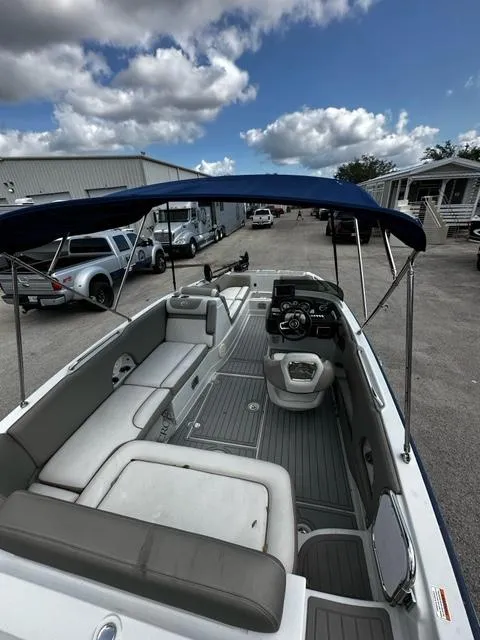 Slide: The Image of 2019 Crownline 205XS boat with canopy, spacious seating, and modern dashboard. - 5