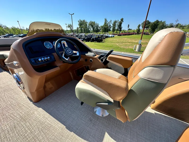 Slide: The Image of 2023 Tahoe Pontoon Cascade Versatile Rear Lounger helm with captain's chair and dashboard. - 28