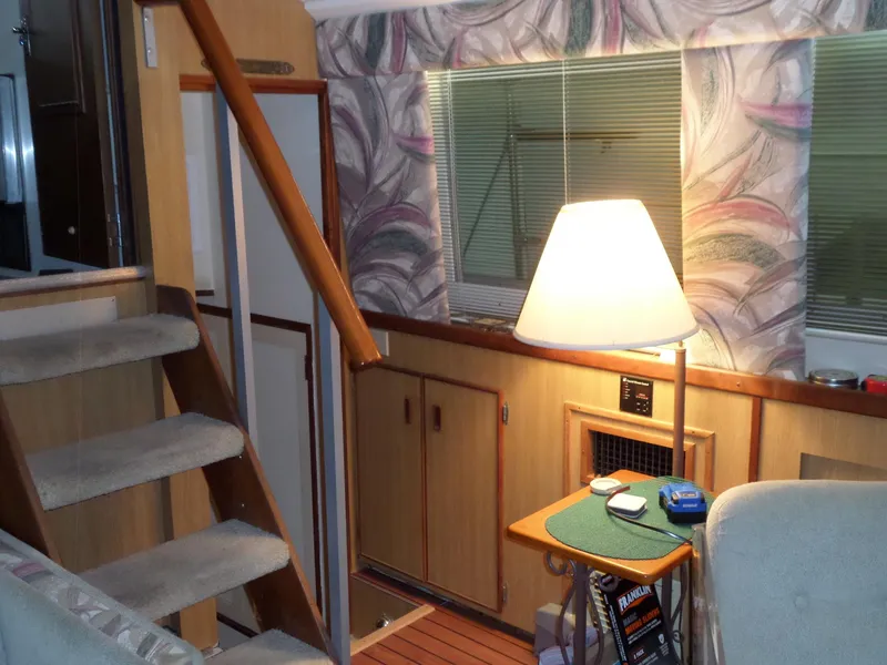 Slide: The Image of Interior of 1978 Bertram 42 Flybridge Motor Yacht with cozy seating and lamp. - 10